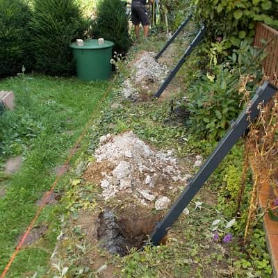 Pfosten f&uuml;r Doppelstabzaun in Fundament betonieren.